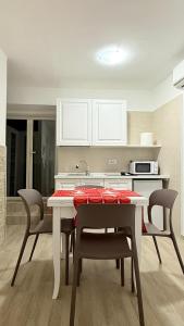 a kitchen with a table and chairs and a kitchen with white cabinets at Ginevra house in Naples