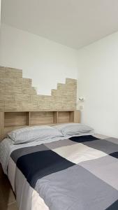 a bed with a wooden headboard in a room at Ginevra house in Naples