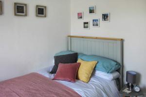 a bedroom with a bed with colorful pillows on it at Colchester, Cosyquietopen Firepatiopetstrain in Wivenhoe
