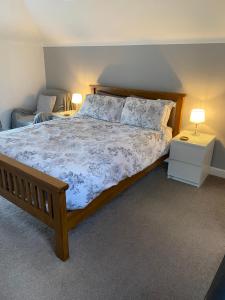 a bedroom with a large bed and a chair at The Dairy in Bagilt