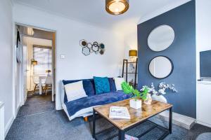 a living room with a blue couch and a table at Colchester Cntrcosyofficepatiotrainparkpet in Colchester