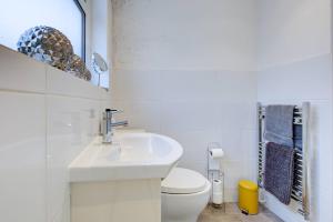 a white bathroom with a sink and a toilet at Colchester Cntrcosyofficepatiotrainparkpet in Colchester +10 photos