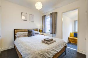 a bedroom with a large bed and a window at Colchester Cntrcosyofficepatiotrainparkpet in Colchester