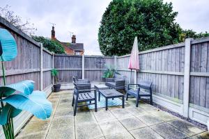 a patio with chairs and a table and an umbrella at Colchester Cntrcosyofficepatiotrainparkpet in Colchester