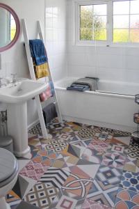 a bathroom with a tub and a sink and a toilet at Colchester, Cosyquietopen Firepatiopetstrain in Wivenhoe