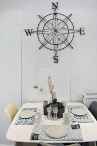 a white table with plates and a wheel on the wall at Colchester, Cosyquietopen Firepatiopetstrain in Wivenhoe