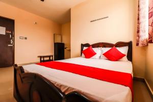 a bedroom with a large bed with red pillows at Hotel O Thirumala Boarding & Lodge in Bengaluru +22 photos