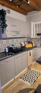 une cuisine avec des armoires blanches et du carrelage noir et blanc dans l'établissement Willa Chańcza, à Chańcza