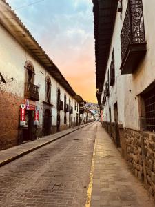 an empty street in an alley with buildings at Casona Tres Reyes in Cusco