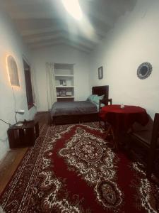a living room with a bed and a rug at Casona Tres Reyes in Cusco