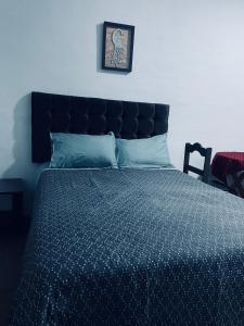 a bedroom with a bed with a blue comforter at Casona Tres Reyes in Cusco