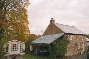 an old brick building with ivy on it at The Little Welsh Cottage in Brynmenin