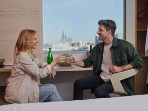 un hombre y una mujer sentados en una mesa hablando en ibis Sydney Darling Harbour, en Sídney 62 fotos más