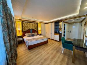 a bedroom with a bed and a table and a desk at can palace adalya otel in Antalya