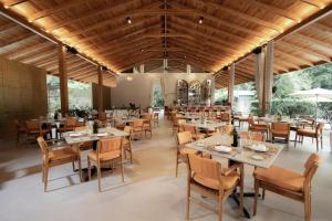 a restaurant with tables and chairs in a room at Astra Hotel Boutique in Nosara