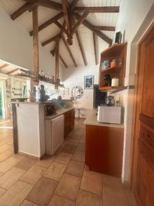 a large kitchen with white appliances and wooden ceilings at Kazatibois à Vieux Fort in Vieux-Fort