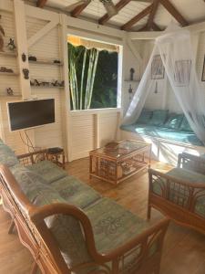 a living room with two beds and a tv at Kazatibois à Vieux Fort in Vieux-Fort