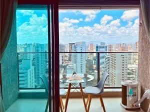 Una mesa y sillas en una habitación con una ventana grande. en Beach Class Meireles by Holiday Stays, en Fortaleza