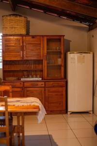 eine Küche mit Holzschränken und einem Kühlschrank in der Unterkunft Chale 19 Praia do BarroPreto in Luis Correia + 66 Fotos