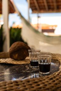 Zwei Gläser Wasser und ein Laib Brot auf einem Tisch. in der Unterkunft Chale 19 Praia do BarroPreto in Luis Correia