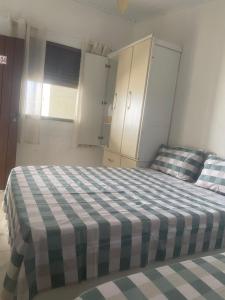 a bedroom with a bed with a checkered blanket at ElRancho Suites in Itaparica Town