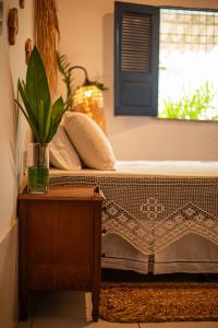 Bett in einem Zimmer mit einem Tisch und einem Fenster in der Unterkunft Chale 19 Praia do BarroPreto in Luis Correia