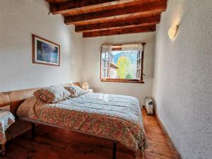 ein Schlafzimmer mit einem Bett und einem Fenster in der Unterkunft El Pirineo te espera- Chimenea, sol y ambiente acogedor con jardín - Cosmos 1 in Pla de l'Ermita