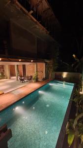 a large swimming pool at night with lights on it at The Kheak in Weligama