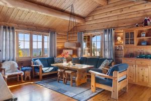 a living room with a table and blue chairs at Trysilfjell 440 by Vacation Trysil in Hovi
