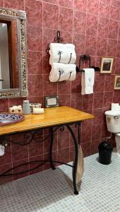 a bathroom with a table with towels and a toilet at hotel gardenias in Pátzcuaro