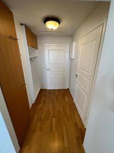 an empty hallway with a white door and wooden floors at Charming one-bedroom apartment in Grand House in the city center of Kokkola in Kokkola