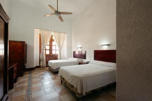 a bedroom with two beds and a ceiling fan at Hotel Nueva Antequera in Oaxaca City +86 photos