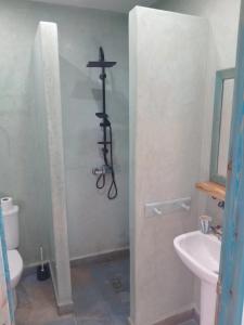 um banheiro com uma cruz religiosa na parede em Appartement Les Vagues Vue sur Mer pour familles em Oualidia