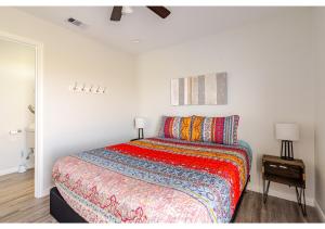 - une chambre avec un lit et une couverture colorée dans l'établissement Sunset Bellini with Hot Tub and Golf Cart!, à Bolivar Peninsula