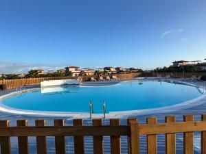 a large blue swimming pool with a wooden fence at Private Terrace Majanicho Home in Majanicho