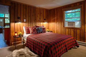 1 dormitorio con 1 cama con manta a cuadros y ventana en Gorgeous Chalet in the Poconos w/ Hot Tub!, en Locust Lakes Village 48 fotos más