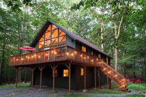 una casa con una escalera en medio de un bosque en Gorgeous Chalet in the Poconos w/ Hot Tub!, en Locust Lakes Village