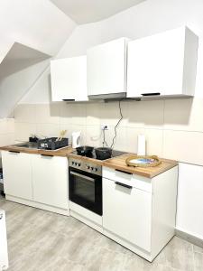 a kitchen with white cabinets and a stove top oven at Aparthotel in Chemnitz