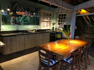 a kitchen with a wooden table and some chairs at Suíte e Sala com Vista para o Mar - Barra do Sahy in São Sebastião