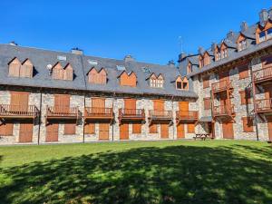a large building with a grass yard in front of it at Tu rincón- Planta baja con jardín y parking - Dellui 2 in Pla de l'Ermita