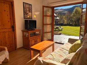 a living room with a couch and a tv and a table at Tu rincón- Planta baja con jardín y parking - Dellui 2 in Pla de l'Ermita