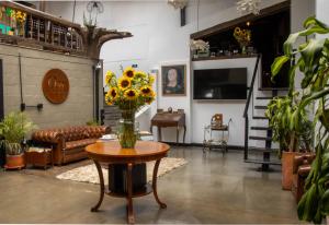 a living room with a couch and a table with flowers at Hotel Quinta Bolivar in Bogotá