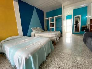 a bedroom with two beds and blue walls at Casa Magro depto para 6 in Oaxaca City