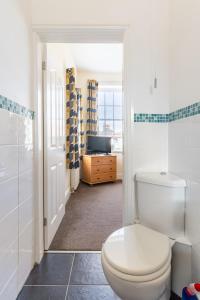a bathroom with a white toilet and a television at A former school converted into a luxury apartment in Rhyl