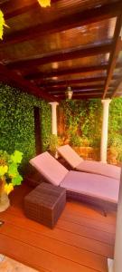 Dos camas en una terraza con una pared verde en Villa Normandie, en Saint-Jean-Cap-Ferrat