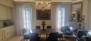 Un comedor con una mesa y sillas y una lámpara de araña. en Villa Normandie, en Saint-Jean-Cap-Ferrat
