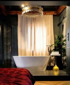 a bath tub in a bathroom with a chandelier at Apartament Plac Zabaw in Łódź