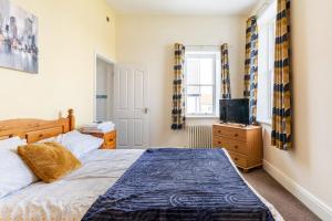 a bedroom with a bed and a television at A former school converted into a luxury apartment in Rhyl