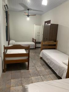 アキダウアナにあるHotel Aquidauanenseのベッド3台と天井ファンが備わる客室です。
