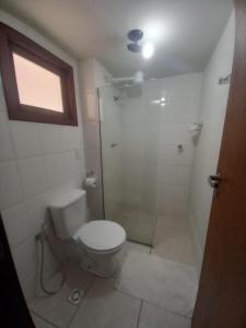 a bathroom with a toilet and a shower at Sol da Pipa Flat Condominio La Piazzeta in Pipa